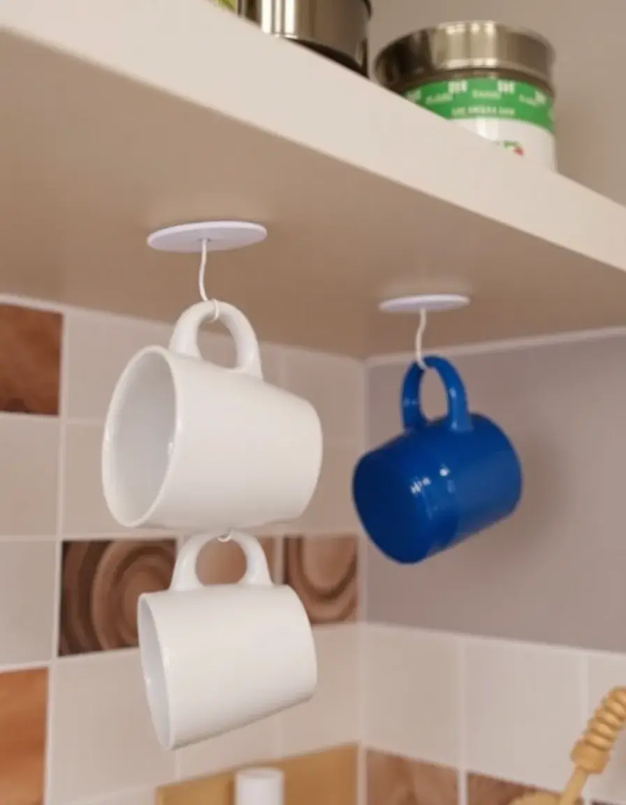 Selbstklebende Haken unter dem Regal zum Aufhängen von Tassen